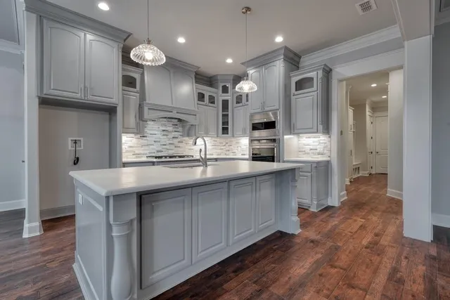 a kitchen with kitchen island granite countertop a sink and cabinets