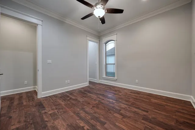 a view of an empty room with window and wooden floor