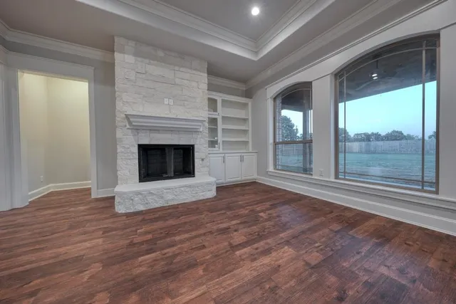 wooden floor fireplace and windows in an empty room