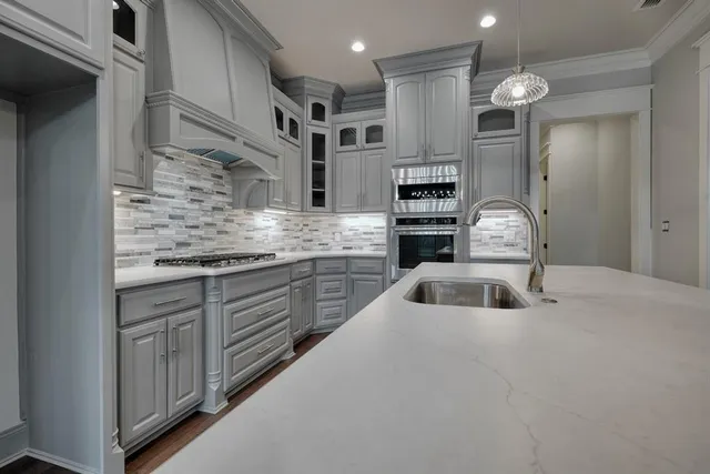 a kitchen with stainless steel appliances granite countertop a sink and cabinets