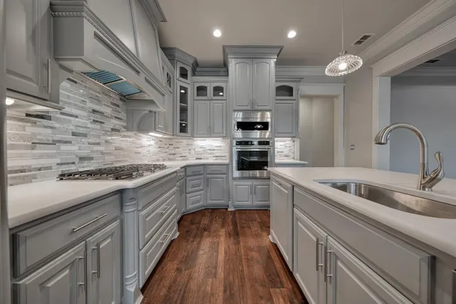 a kitchen with stainless steel appliances granite countertop a sink and cabinets