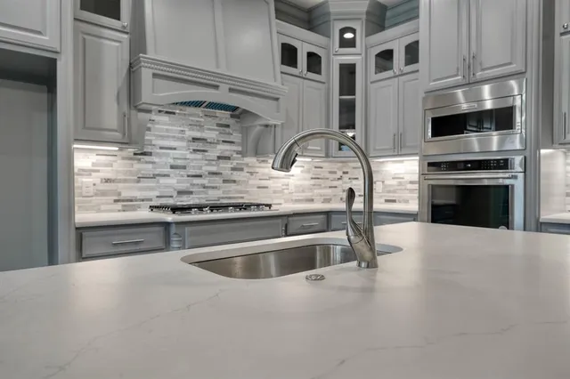 a kitchen with kitchen island granite countertop a stove and a sink