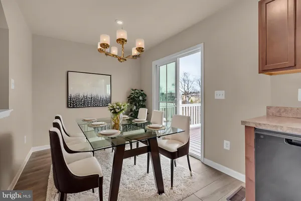 a view of a dining room with furniture a chandelier and wooden floor