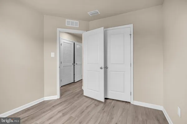 an empty room with wooden floor and closet