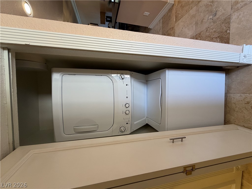210 East Flamingo Road, Unit 426 Las Vegas, NV 89169 - Photo 15 of 17 A compact laundry area featuring a washer and dryer unit for ultimate convenience.