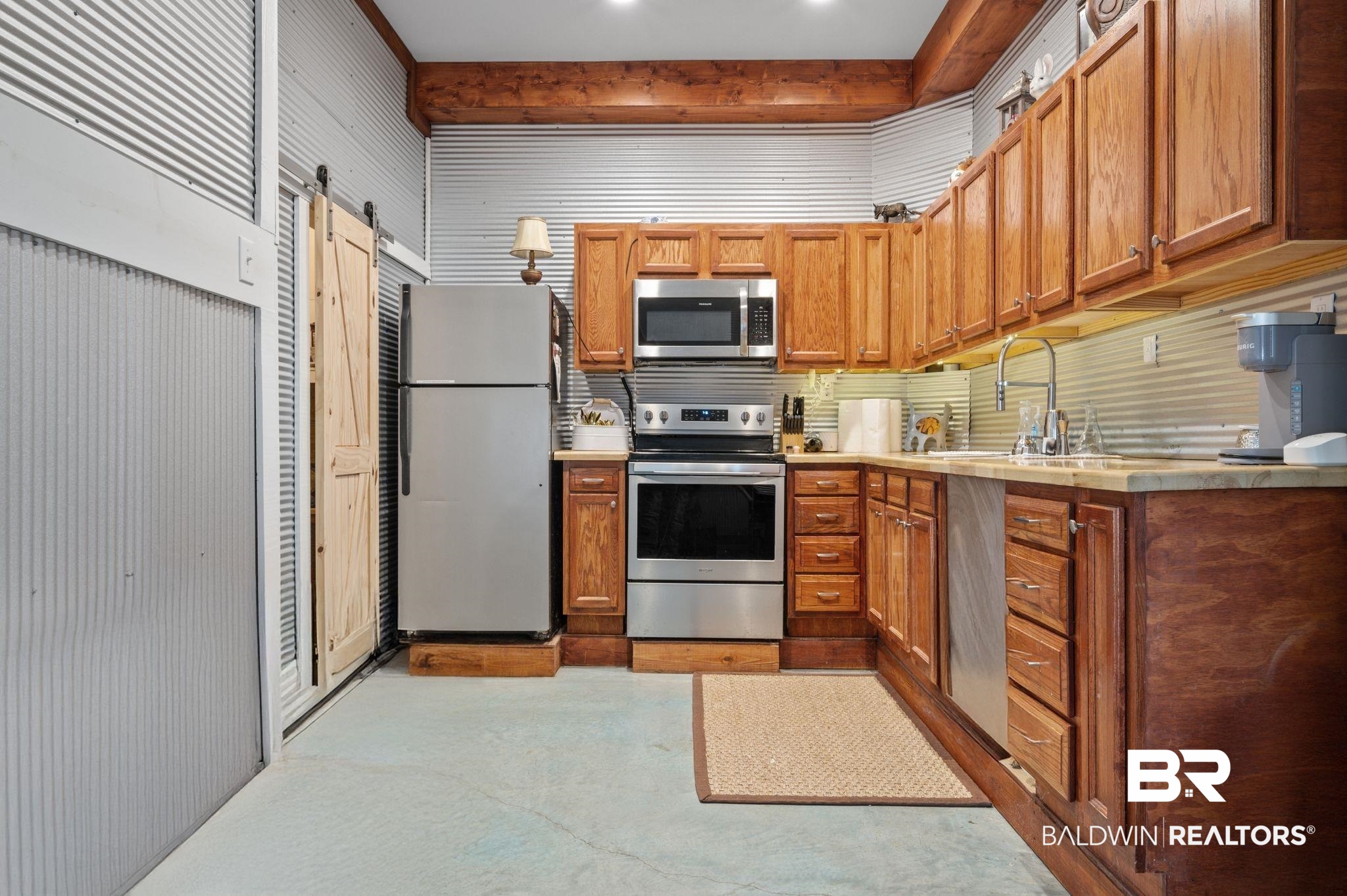 3840 Cotton Way Orange Beach, AL 36561 - Photo 56 of 75 Kitchen with beamed ceiling, a barn door, stainless steel appliances, and sink