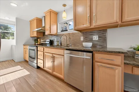 a kitchen with stainless steel appliances granite countertop a sink and cabinets