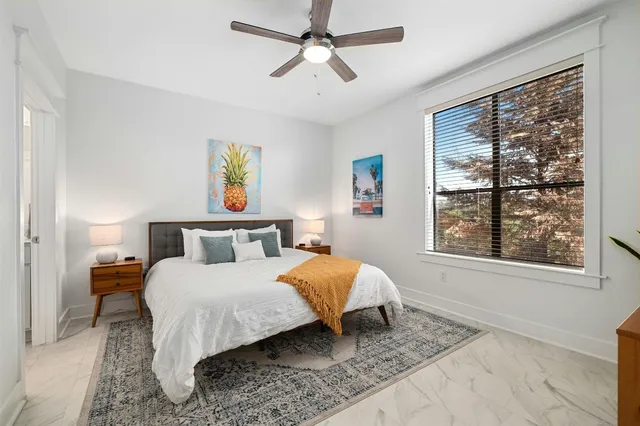 a bedroom with a bed lamp and a window