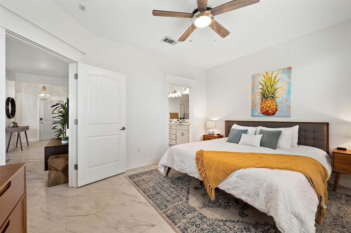 17800 Edgewood Way, Unit 202 Jonestown, TX 78645 - Photo 16 of 40 a bedroom with a bed and a chandelier