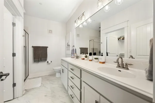 a bathroom with a sink a toilet and shower