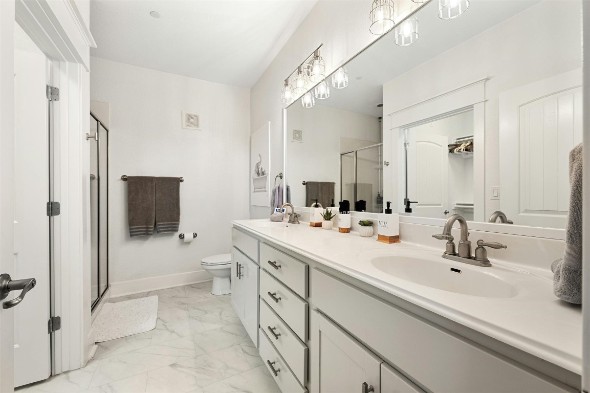 17800 Edgewood Way, Unit 202 Jonestown, TX 78645 - Photo 19 of 40 a bathroom with a sink a toilet and shower