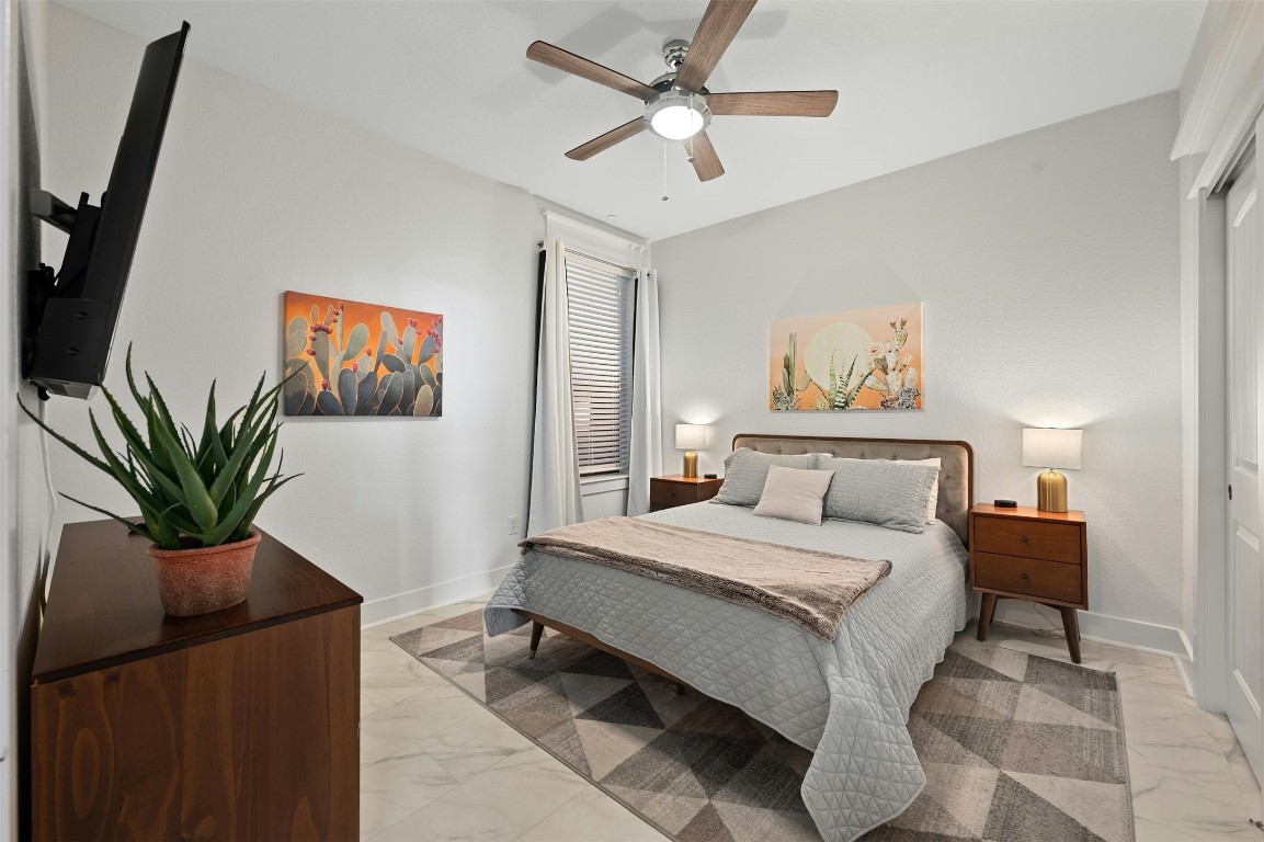 17800 Edgewood Way, Unit 202 Jonestown, TX 78645 - Photo 20 of 40 a bedroom with a large bed and a chandelier