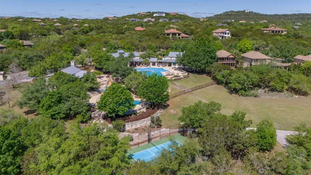 an aerial view of residential houses with outdoor space and trees