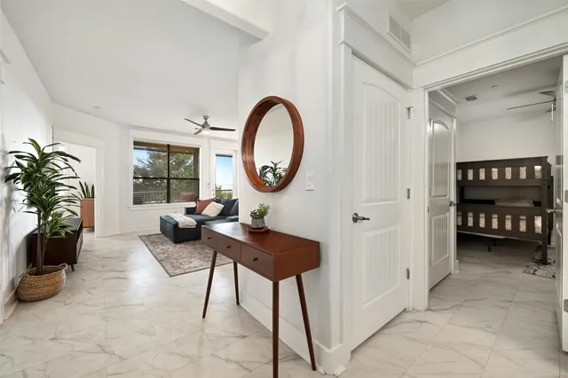 a living room with furniture a potted plant and a large window