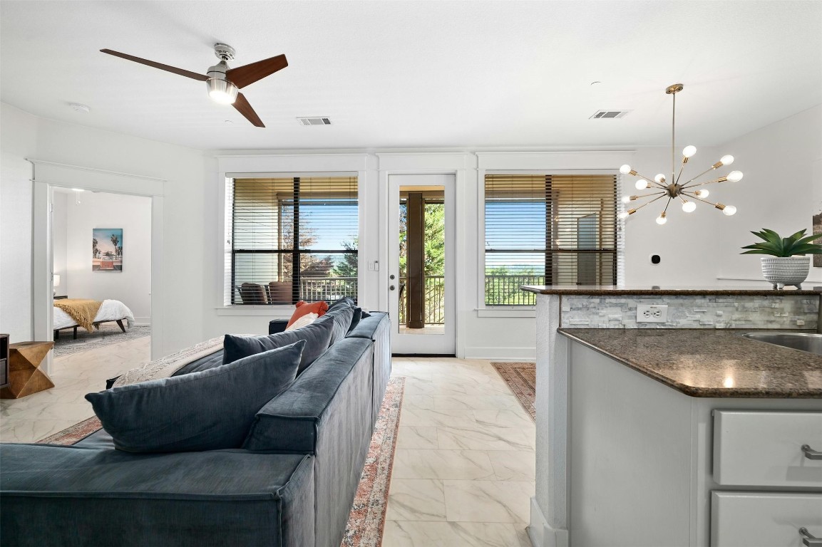 17800 Edgewood Way, Unit 202 Jonestown, TX 78645 - Photo 10 of 40 a living room with furniture and a chandelier
