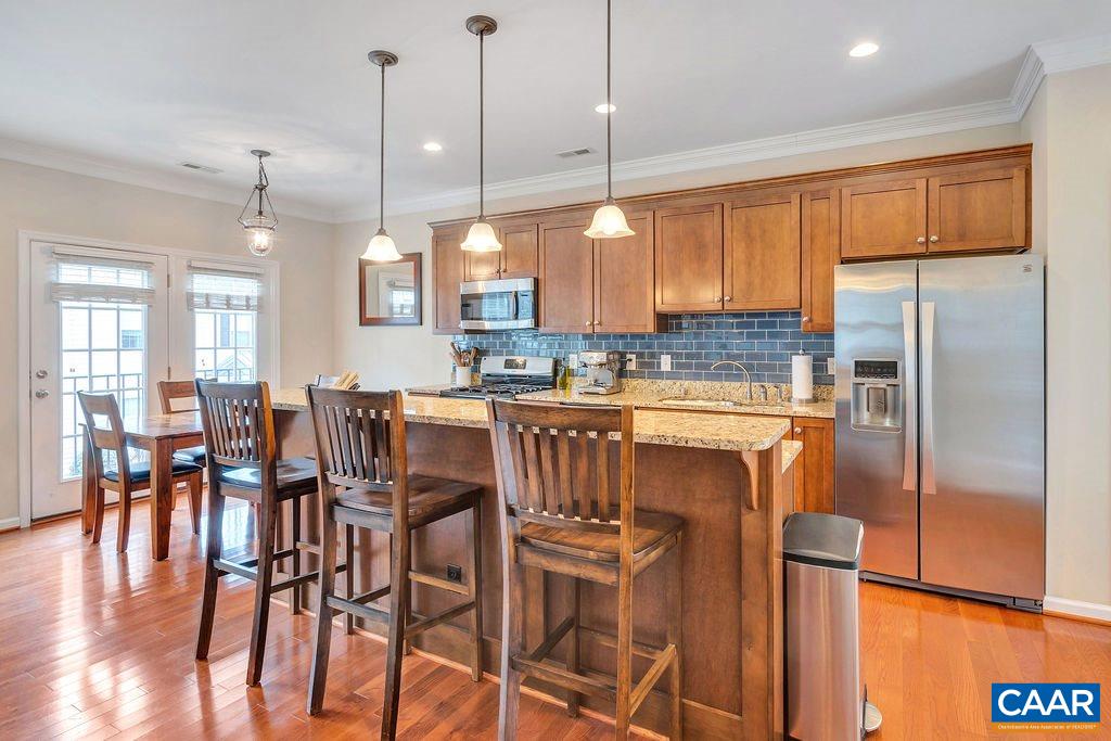 341 Quarry Road Charlottesville, VA 22902 - Photo 7 of 19 a kitchen with stainless steel appliances a dining table chairs refrigerator and sink
