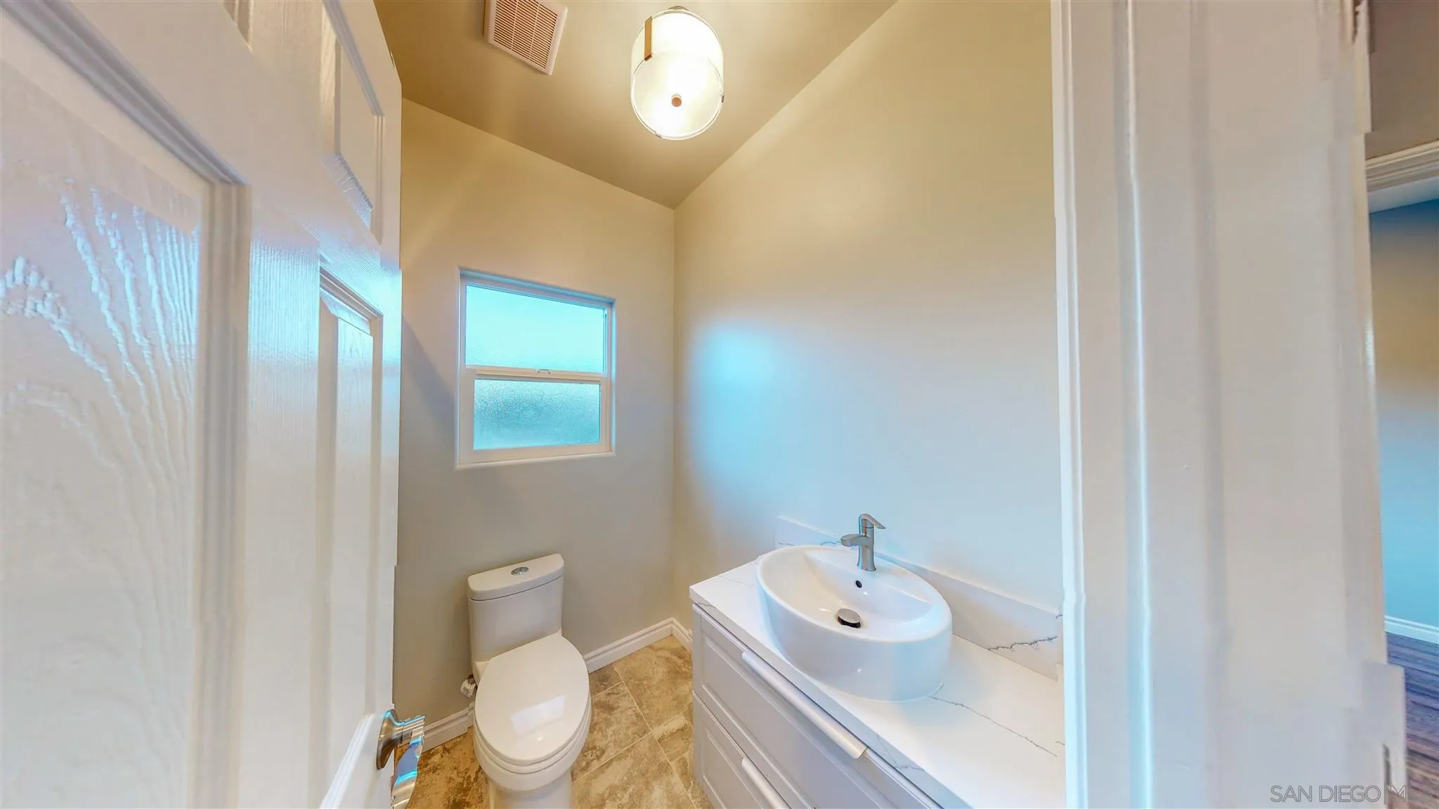 9957 Sierra Madre Road Spring Valley, CA 91977 - Photo 20 of 46 a bathroom with a toilet sink and mirror