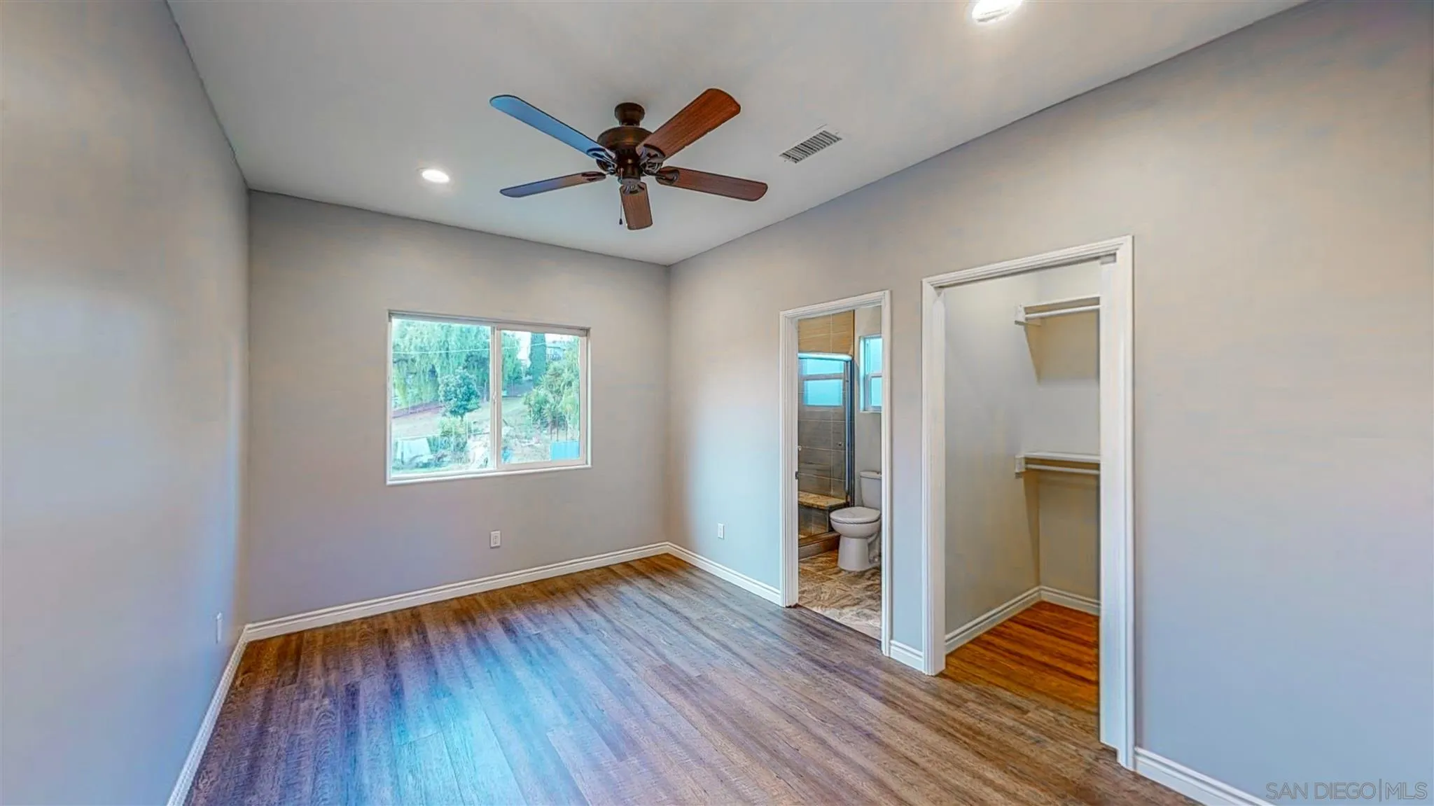 9957 Sierra Madre Road Spring Valley, CA 91977 - Photo 23 of 46 a view of a hallway with wooden floor and a ceiling fan