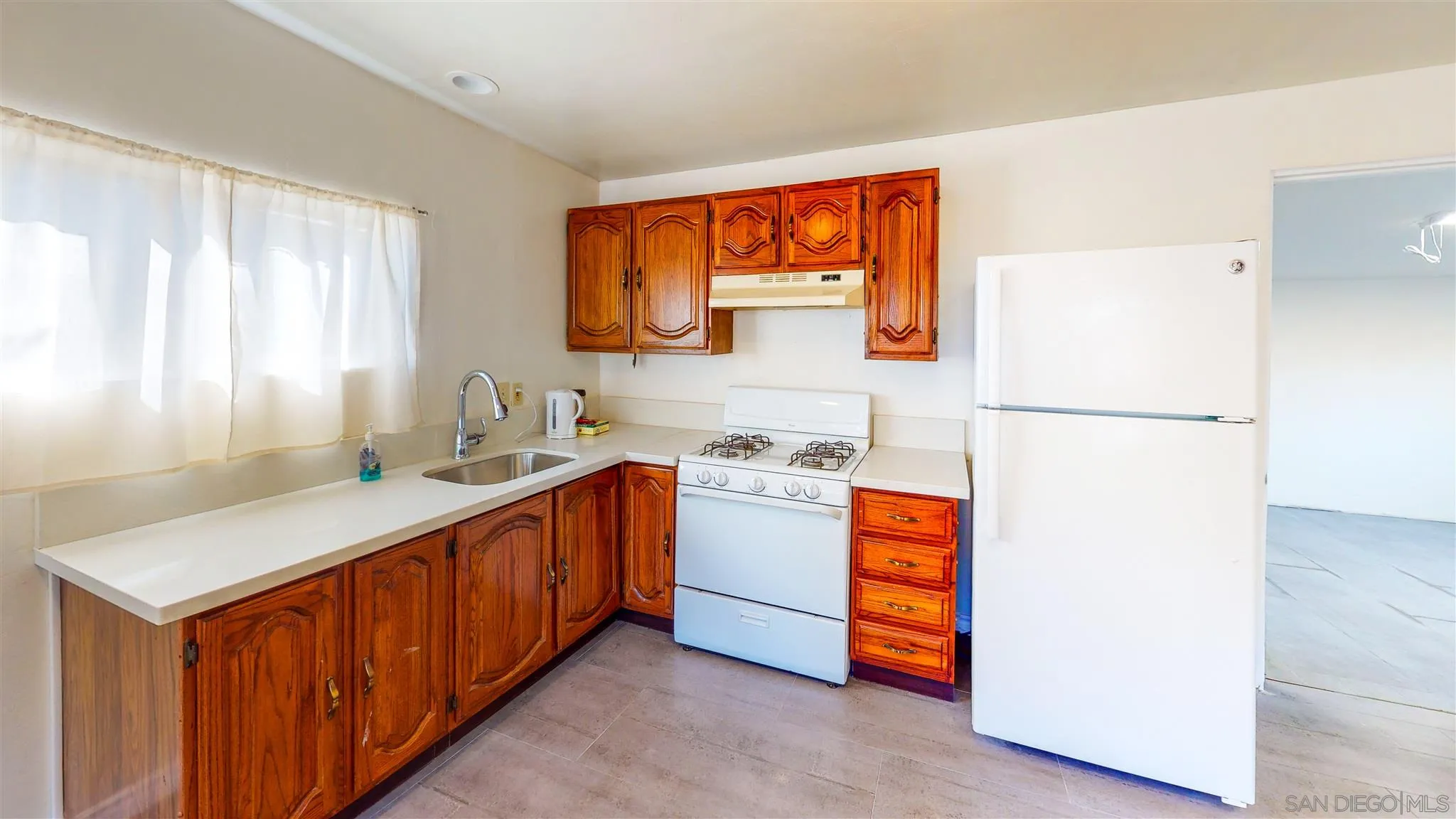 9957 Sierra Madre Road Spring Valley, CA 91977 - Photo 33 of 46 a kitchen with stainless steel appliances granite countertop a refrigerator and a sink