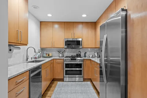 a kitchen with stainless steel appliances granite countertop a refrigerator and a stove top oven