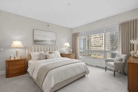 a bedroom with a bed and a couch next to a window