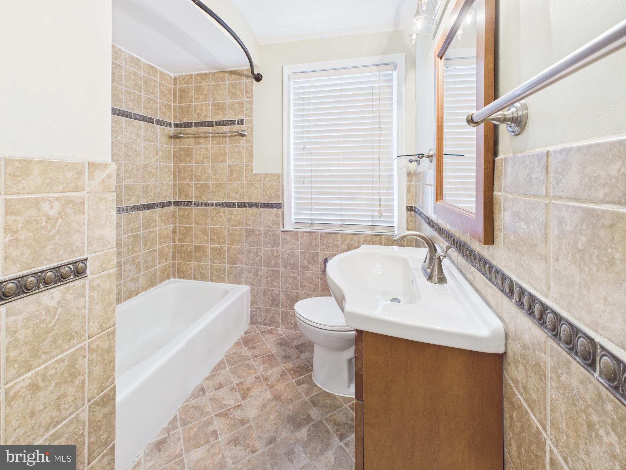 1206 Cedarcroft Road Baltimore, MD 21239 - Photo 14 of 29 a bathroom with a sink a toilet and shower
