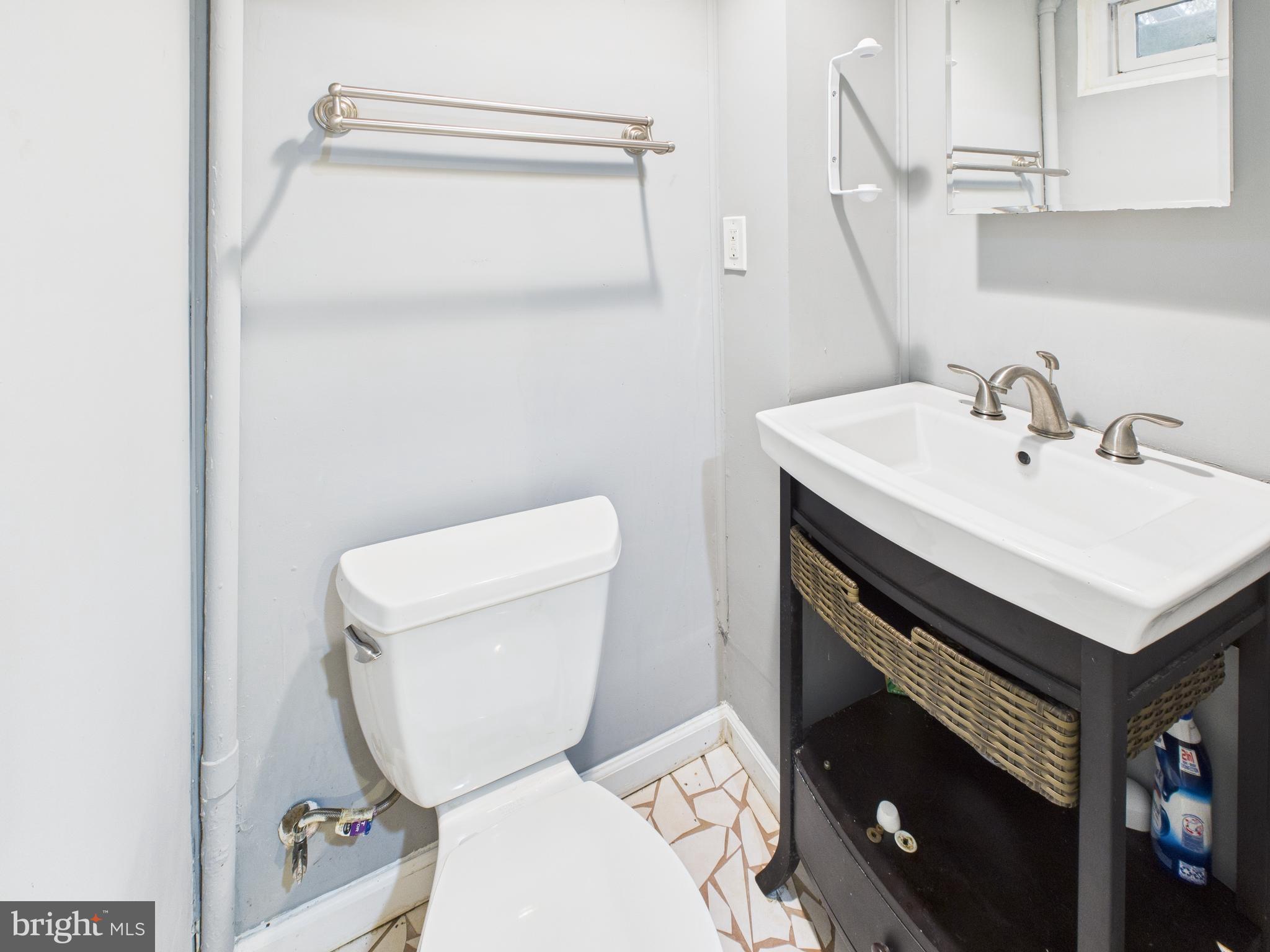 1206 Cedarcroft Road Baltimore, MD 21239 - Photo 20 of 29 a bathroom with a sink a toilet and a mirror