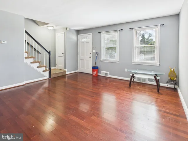 a view of empty room with wooden floor and windows