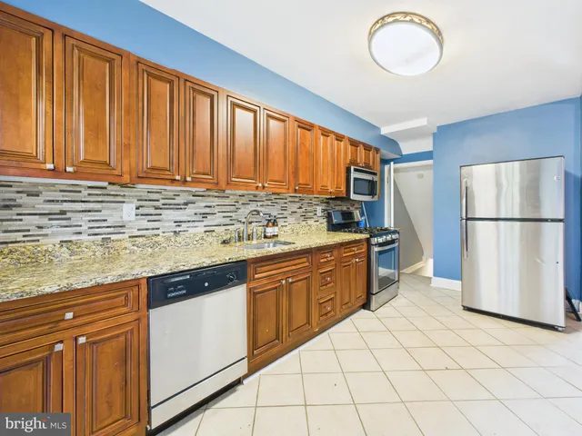 a kitchen with stainless steel appliances granite countertop a refrigerator sink and cabinets