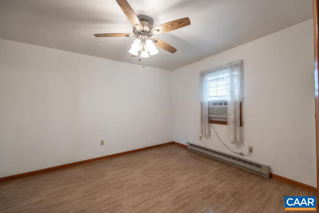 144 Dairy Road Ruckersville, VA 22968 - Photo 16 of 33 an empty room with a chandelier fan and windows