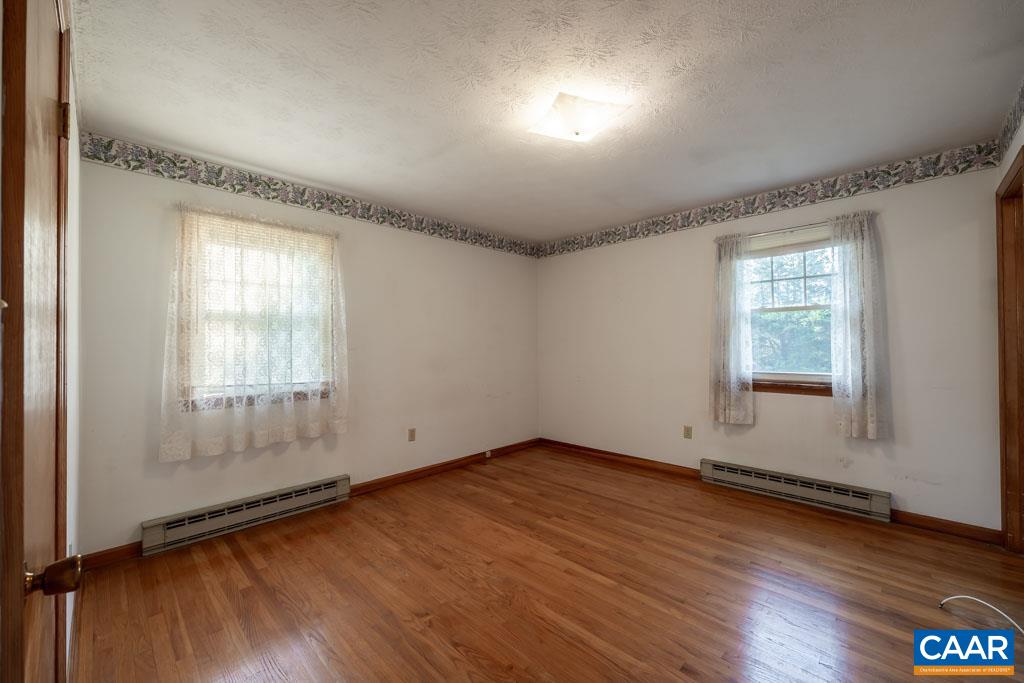 144 Dairy Road Ruckersville, VA 22968 - Photo 22 of 33 an empty room with wooden floor and windows