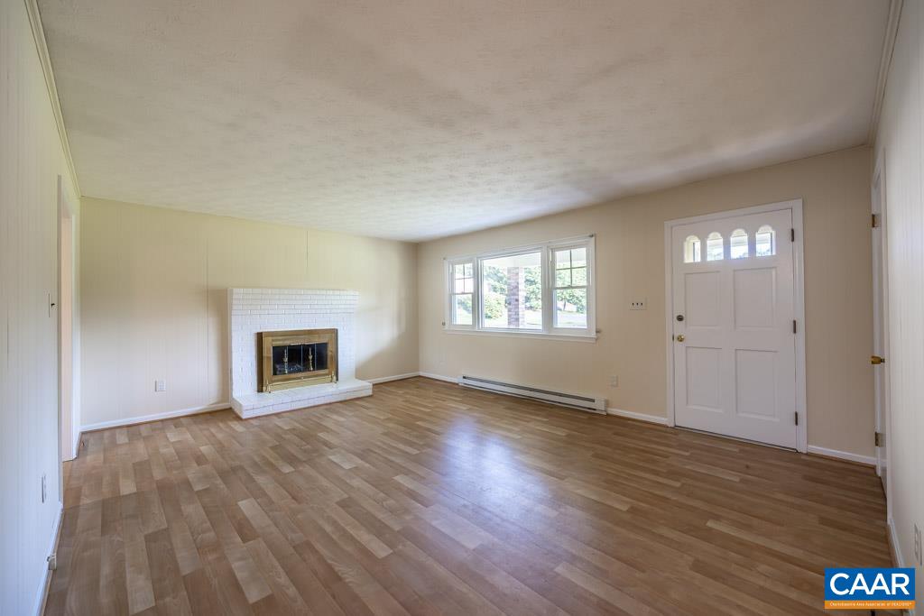 144 Dairy Road Ruckersville, VA 22968 - Photo 26 of 33 an empty room with wooden floor fireplace and windows