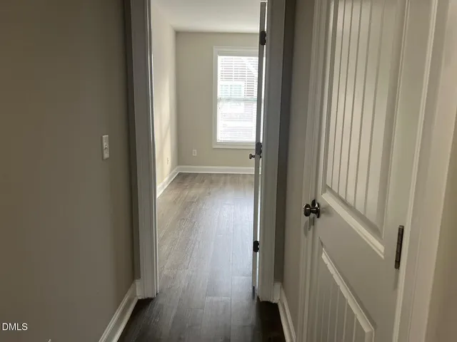 a view of a room that has wooden floor and a window