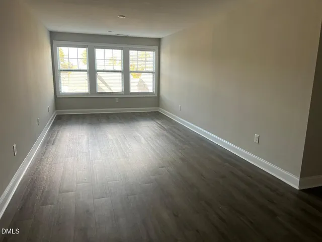 a view of a hallway with wooden floor and a window