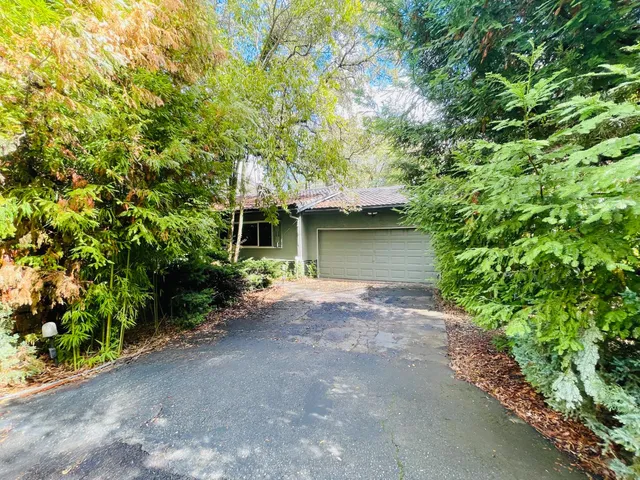 a front view of a house with a yard and a garage