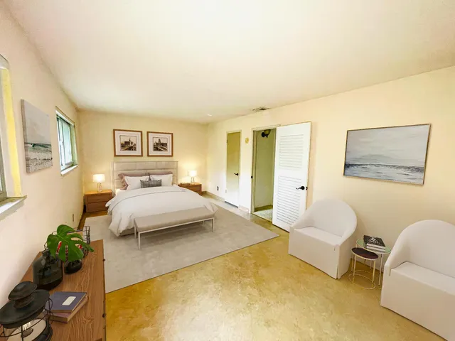 a bedroom with a bed couch and view of living room