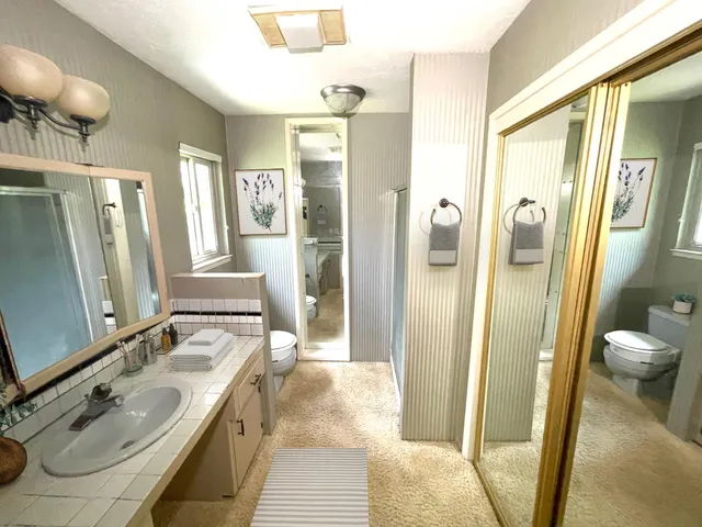 a bathroom with a sink a toilet and shower
