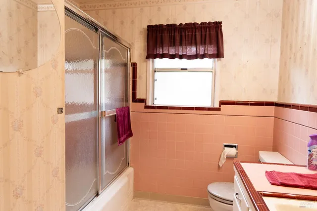 an empty room with a chandelier fan and windows