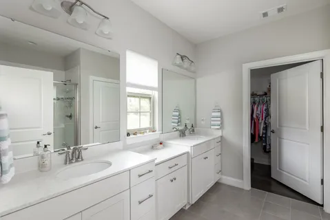 a spacious bathroom with double sink and a mirror