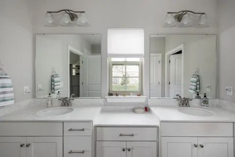 a bathroom with double sink and a mirror