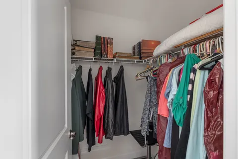 a view of walk in closet with clothes