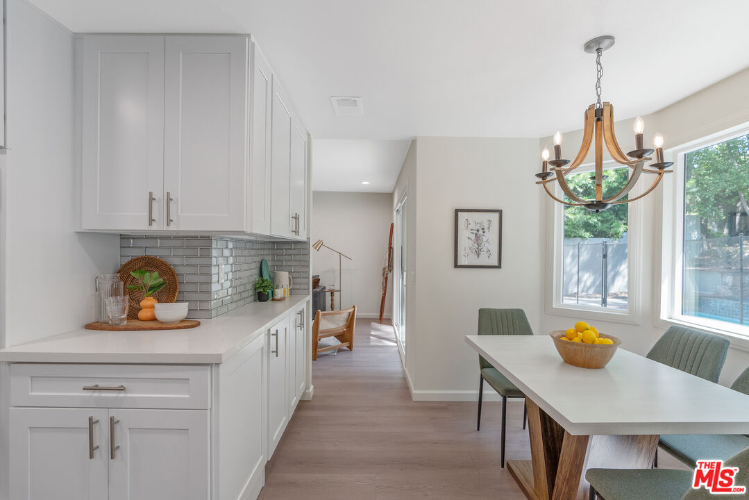 19 Rippling Streme Irvine, CA 92603 - Photo 25 of 69 a kitchen with stainless steel appliances a white wooden cabinets a stove a dining table and chairs