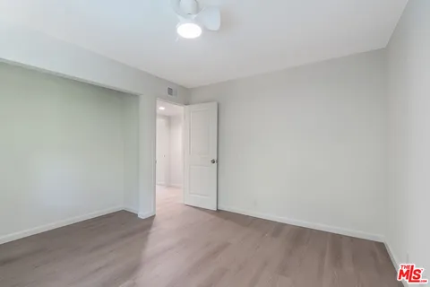 an empty room with wooden floor and mirror