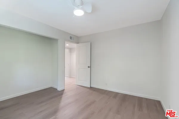 an empty room with wooden floor and mirror