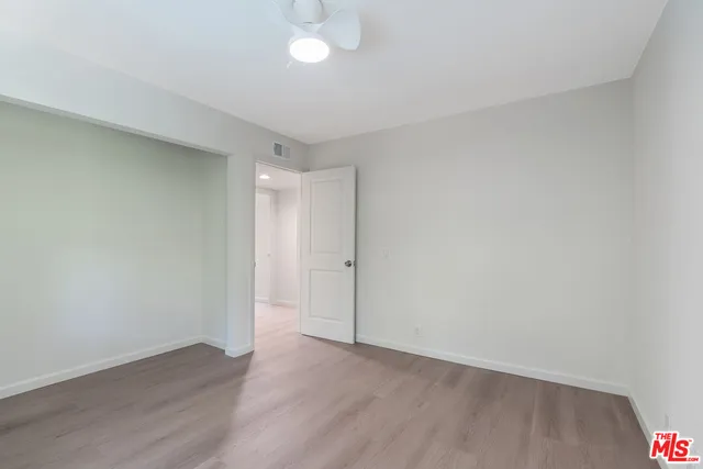 an empty room with wooden floor and mirror