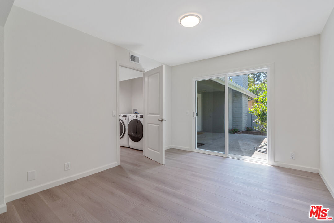 19 Rippling Streme Irvine, CA 92603 - Photo 48 of 69 an empty room with wooden floor and mirror