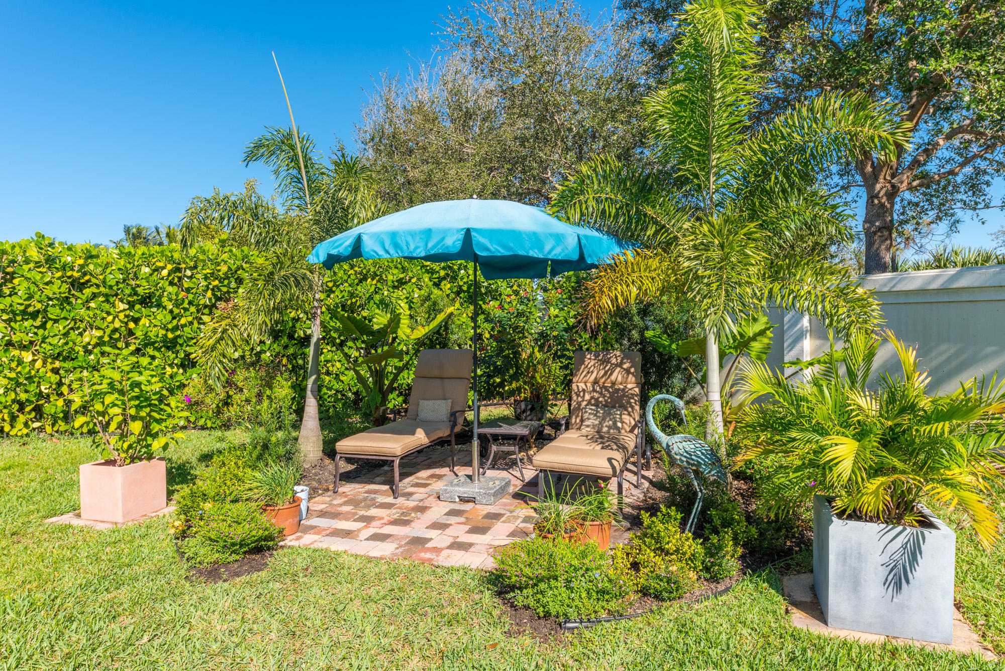151 Rudder Cay Way Jupiter, FL 33458 - Photo 24 of 32 a backyard of a house with table and chairs under an umbrella