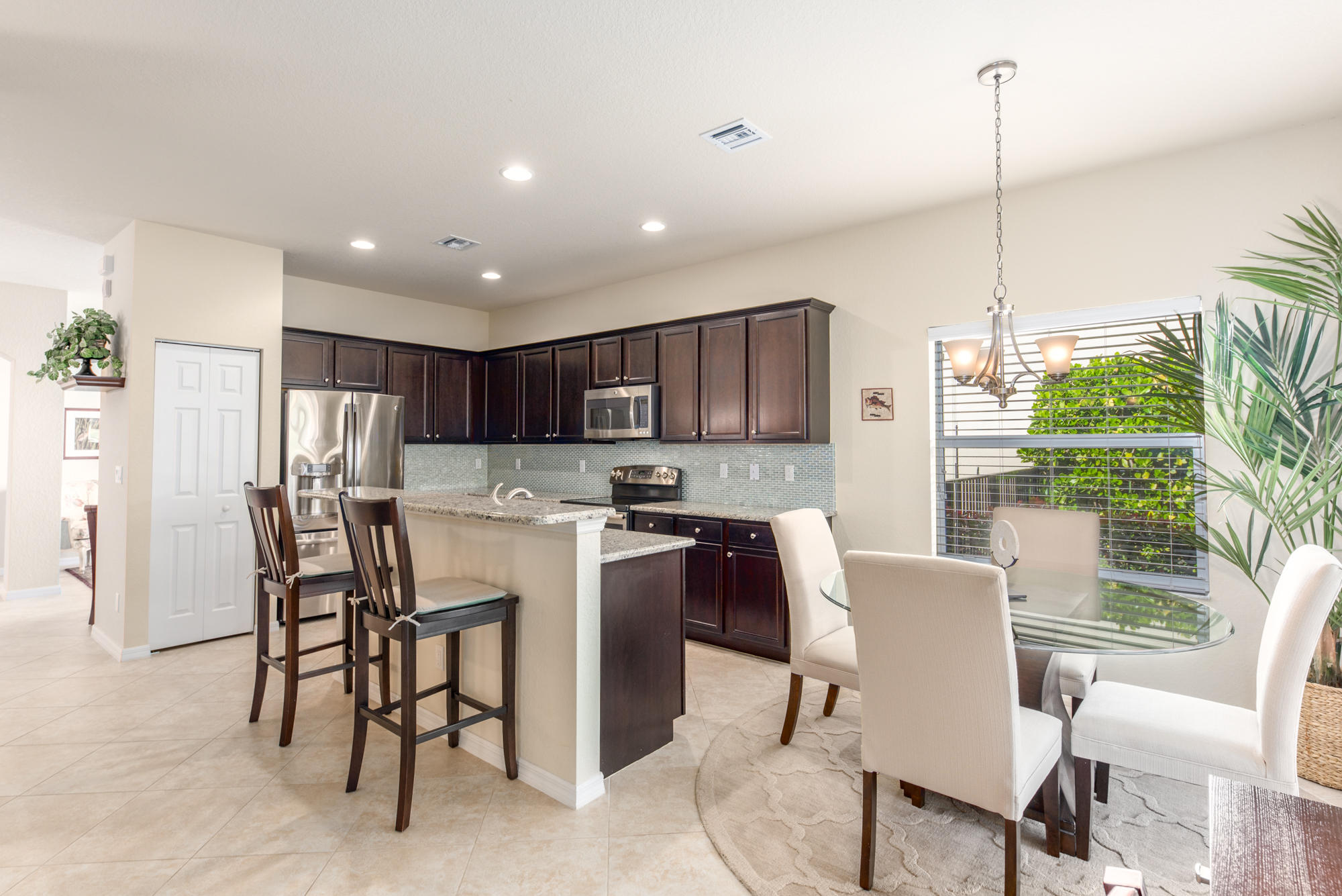 151 Rudder Cay Way Jupiter, FL 33458 - Photo 8 of 32 a kitchen with kitchen island a dining table chairs stainless steel appliances and cabinets