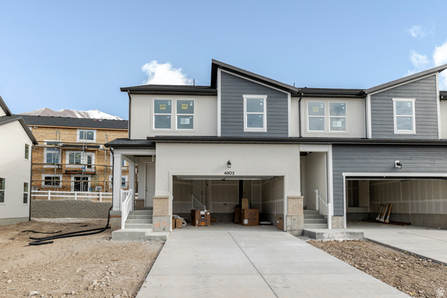 View of front facade featuring a garage and driveway