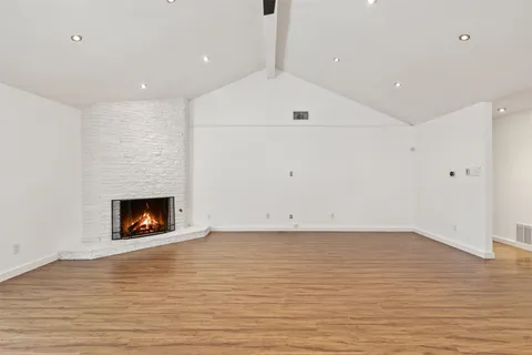 a view of a kitchen with wooden floor and cabinets